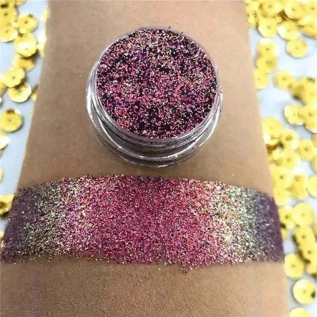 Fard à paupières pailleté rose, violet et doré, présenté en pot avec un large swatch multicolore scintillant.